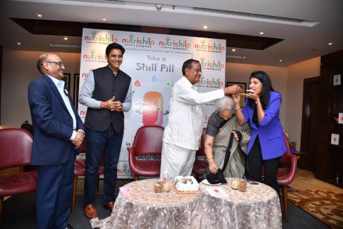 Mr. Gauri Shankar Agrawal giving cake to Shilpi Goel during book launch event of 'Take a Shill Pill'